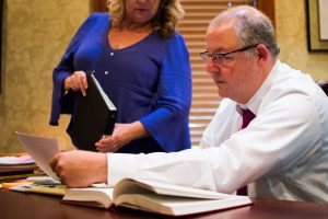 Charles J. Sticklen Jr. reading paperwork at Sticklen Dreyer Tinney Law Firm